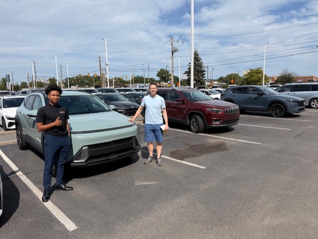 Damarion celebrating a vehicle delivery with a customer at Indy Hyundai