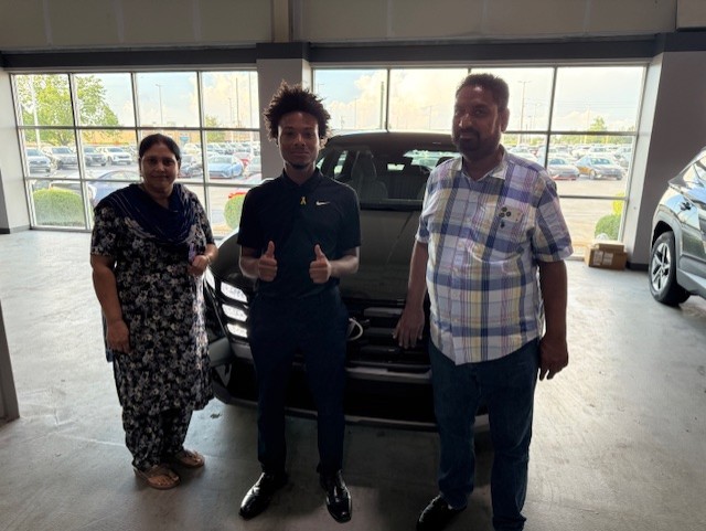Damarion with customers at their vehicle delivery inside Indy Hyundai